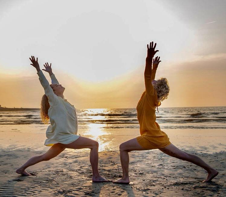 strandyoga aan zee met uitzicht op de zonsondergang